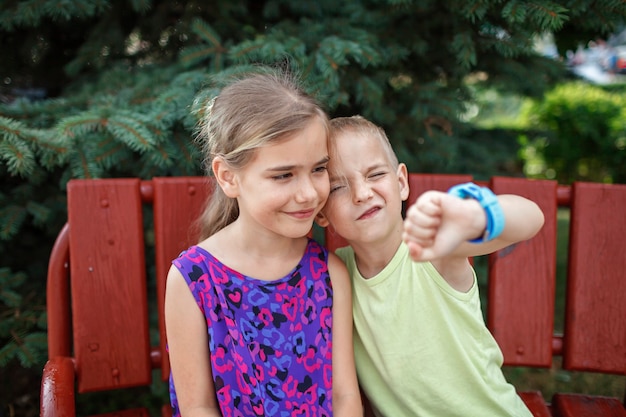 Kinder, die Smartwatches mit Interesse verwenden, und Eltern kontrollieren neue Technologien für Kinder