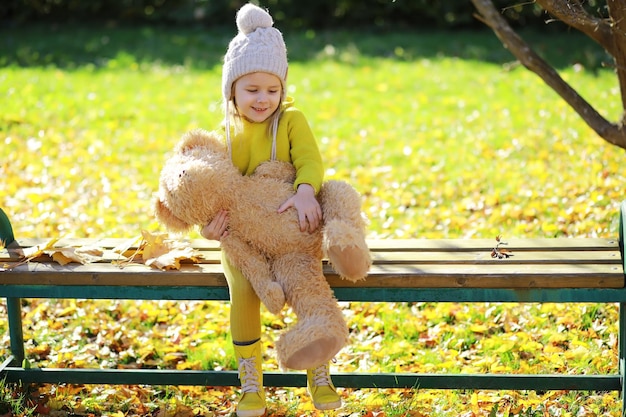 Kinder, die Spaß haben und auf Baum im Herbstwald balancieren