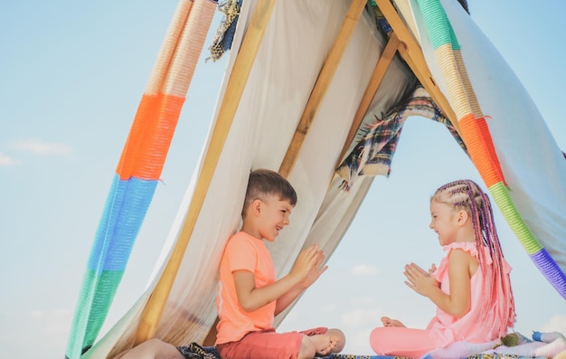 Kinder, die Spaß im Freien haben Bruder und Schwestern, die zusammen spielen Glückliche Kinder, die im Zelt spielen Campingkinder