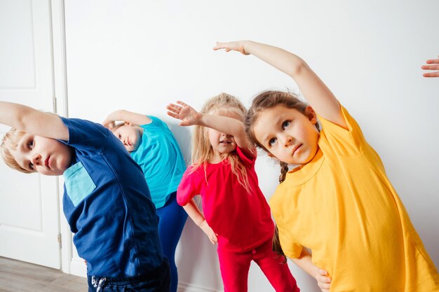 Kinder, die vor dem Gymnastiktraining Dehnübungen machen