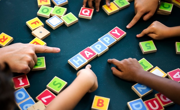 Foto kinder, die wörter mit alphabetblöcken formulieren