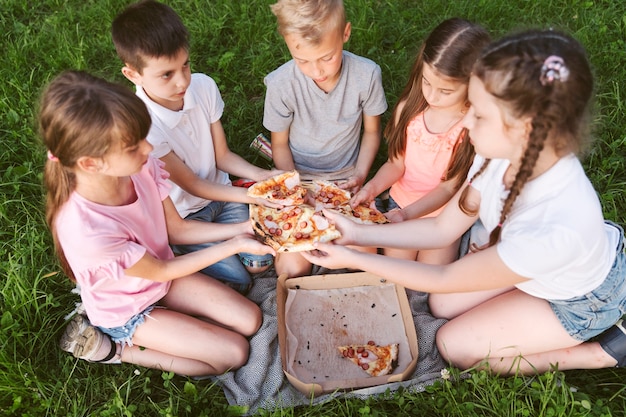 Foto kinder, die zusammen eine pizza teilen