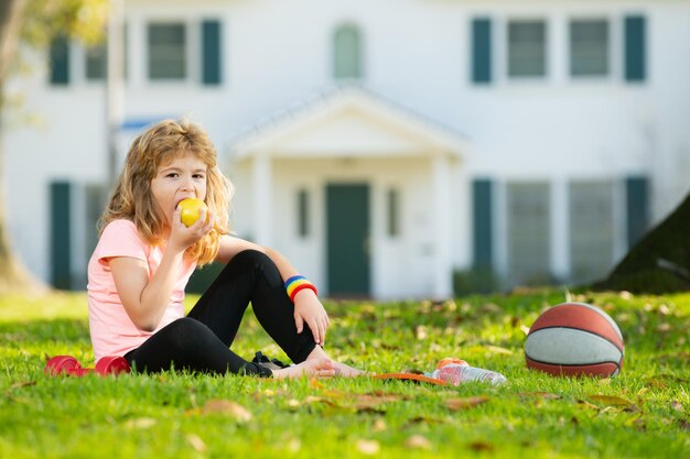 Kinder entspannen sich auf der Sportmatte nach Sportübungen im Freien im Parkkonzept des Kindersports