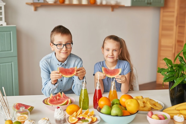 Kinder essen Wassermelonenscheiben in der Küche