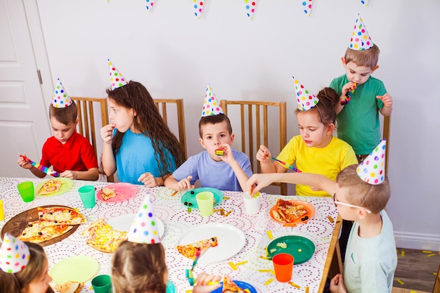 Kinder feiern zusammen den Geburtstag eines Freundes zu Hause