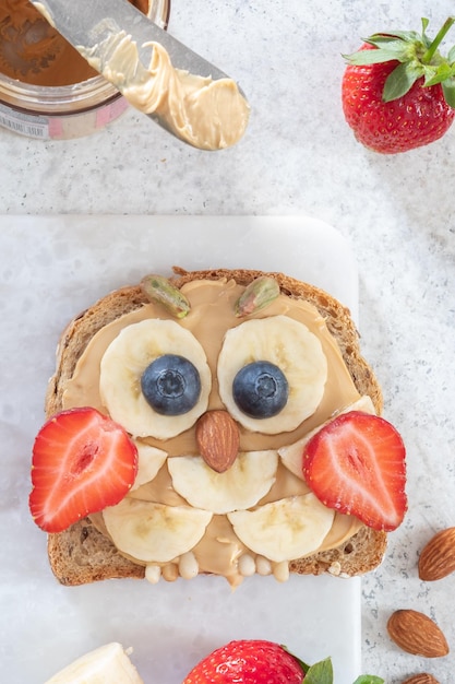 Kinder-frühstückstoast mit erdnussbutter-bananen-erdbeere