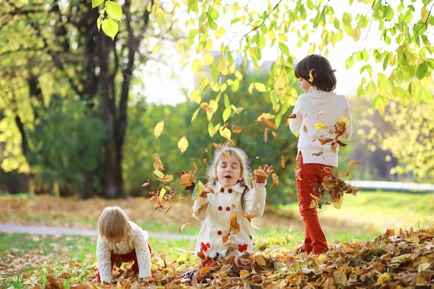 Kinder für einen Spaziergang im Herbstpark. Laubfall im Park. Familie. Herbst. Glück.