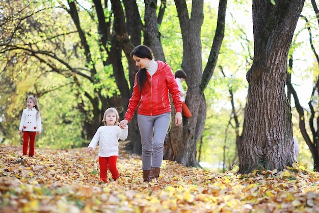 Kinder für einen Spaziergang im Herbstpark. Laubfall im Park. Familie. Herbst. Glück.