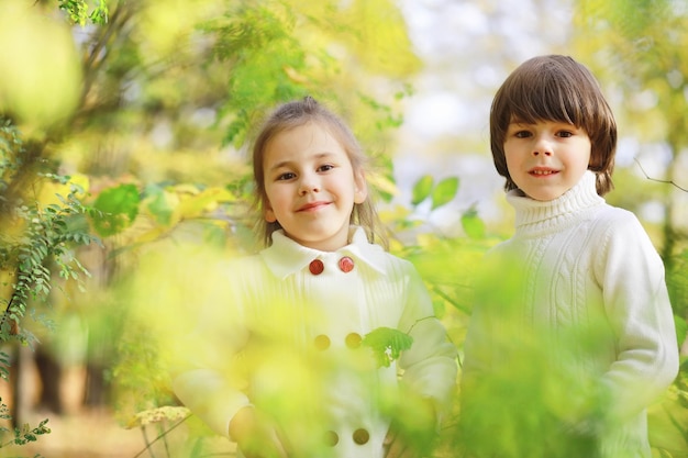 Kinder für einen Spaziergang im Herbstpark Laubfall im Park Familie Herbstglück