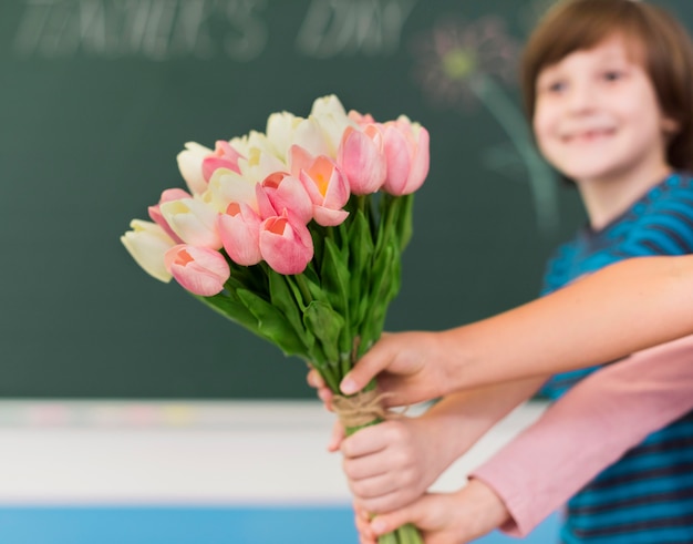Kinder geben Blumen mit Kopierraum