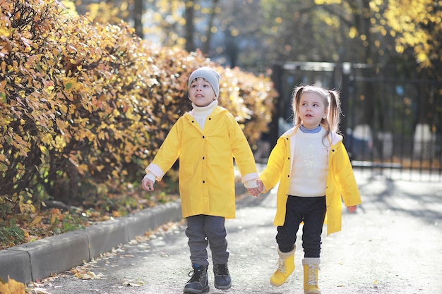 Kinder gehen im Herbst im Herbstpark