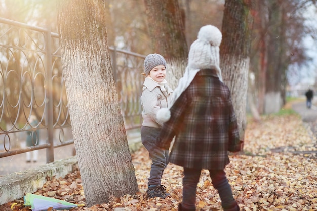 Kinder gehen im Herbst im Herbstpark