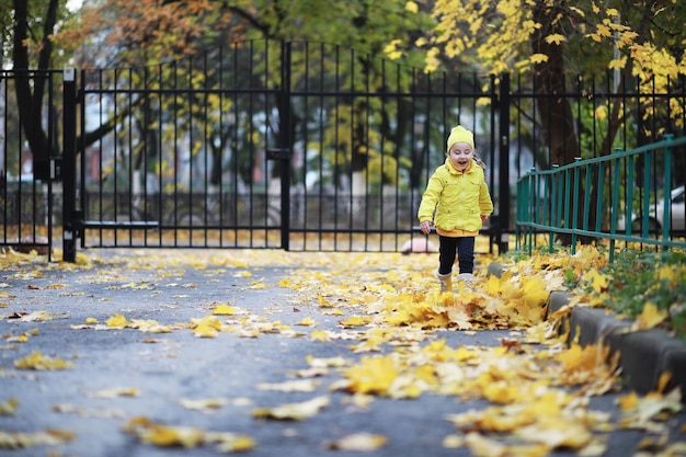 Kinder gehen im Herbst im Herbstpark