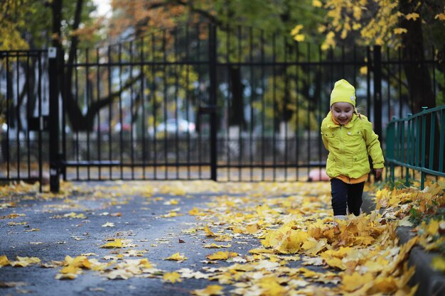 Kinder gehen im Herbst im Herbstpark