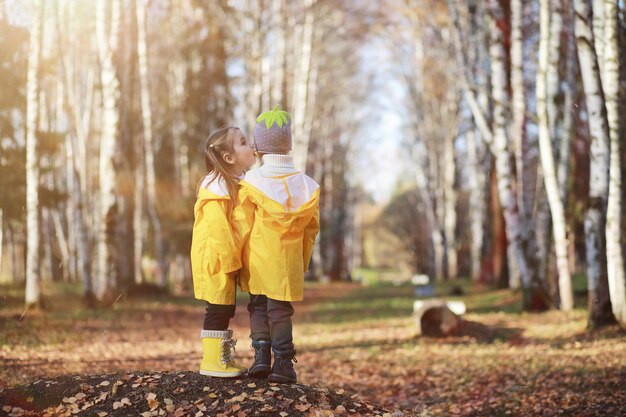 Kinder gehen im Herbst im Herbstpark