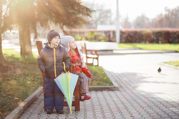 Kinder gehen im Herbst im Herbstpark