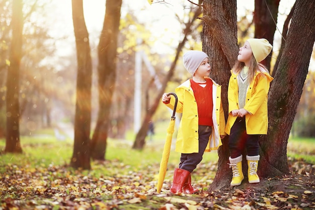 Kinder gehen im Herbst im Herbstpark