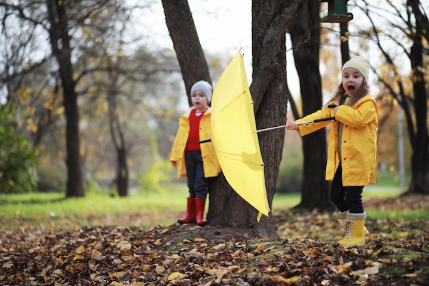 Kinder gehen im Herbst im Herbstpark