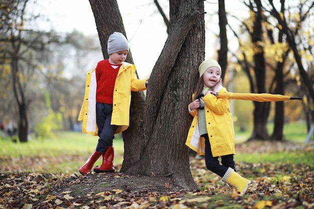 Kinder gehen im Herbst im Herbstpark