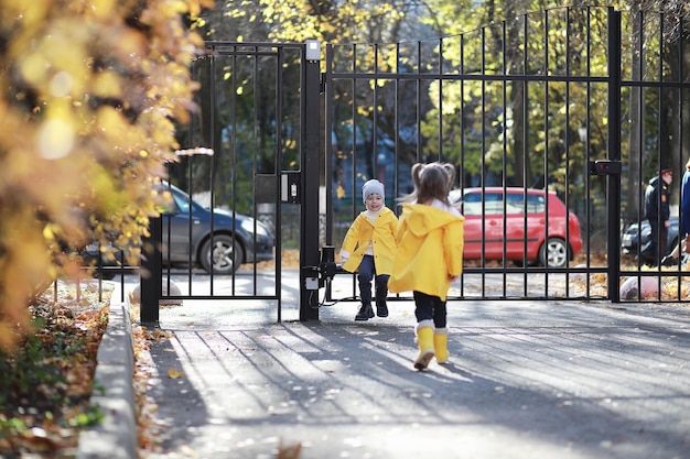 Kinder gehen im Herbst im Herbstpark