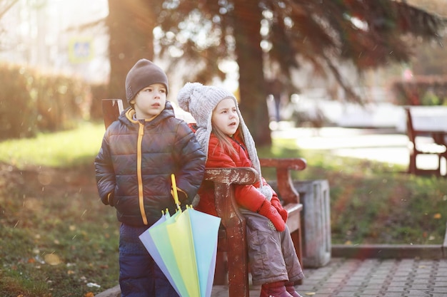 Kinder gehen im Herbst im Herbstpark