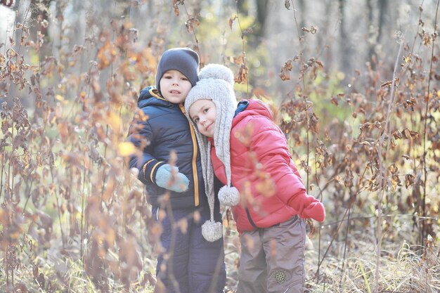 Kinder gehen im Herbstpark spazieren