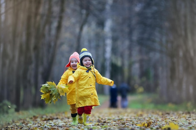 Kinder gehen im Herbstpark spazieren