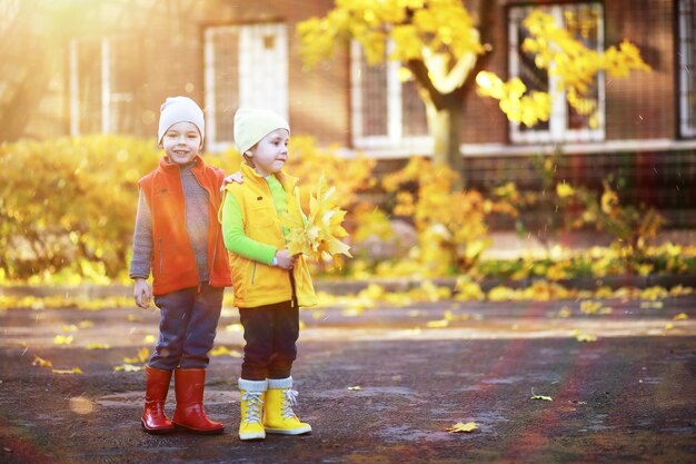 Kinder gehen im Herbstpark spazieren