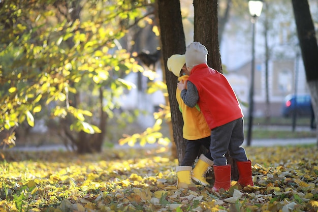 Kinder gehen im Herbstpark spazieren