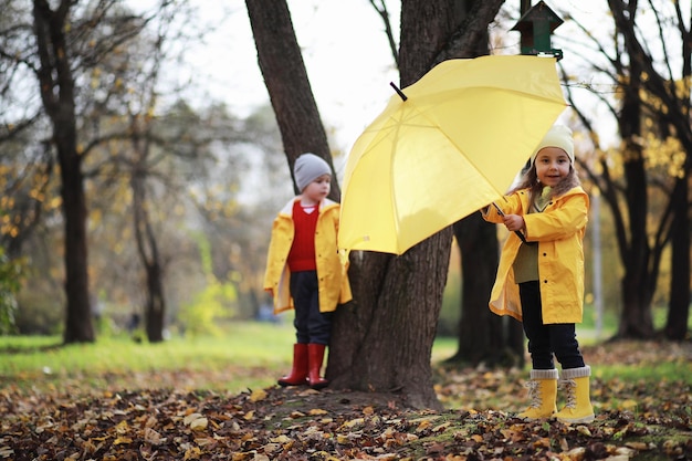 Kinder gehen im Herbstpark spazieren