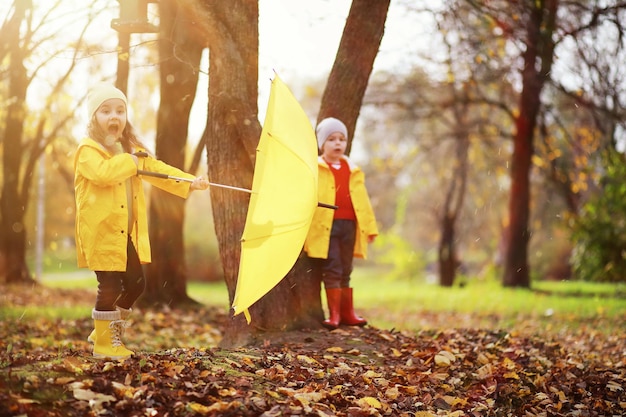 Kinder gehen im Herbstpark spazieren