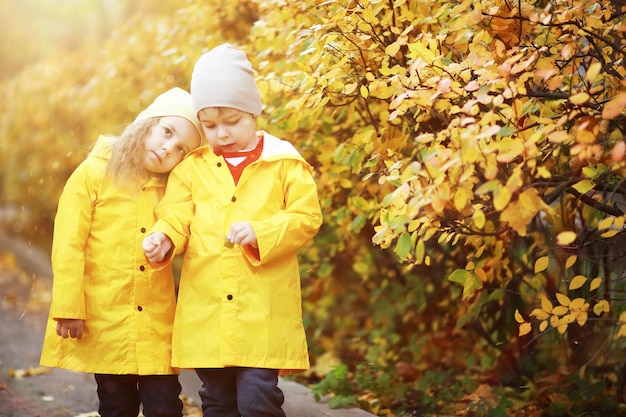 Kinder gehen im Herbstpark spazieren