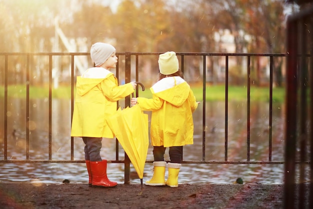 Kinder gehen im Herbstpark spazieren