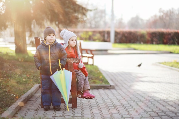 Kinder gehen im Herbstpark spazieren