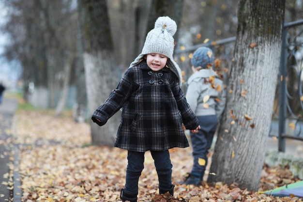 Kinder gehen im Herbstpark spazieren