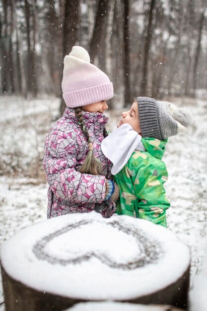 Kinder genießen ersten Schnee im Winterwald, aktive saisonale Aktivitäten, Lebensstil