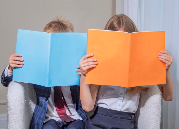 Kinder halten ein Notizbuch mit den im Klassenzimmer zugewiesenen Hausaufgaben in der Hand