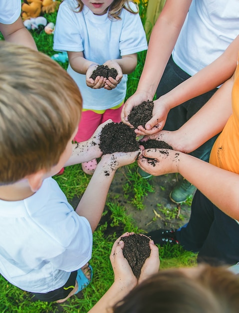 Kinder halten gemeinsam die Erde in den Händen