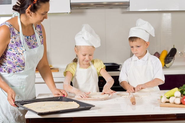 Kinder helfen ihrer Mutter beim Zubereiten des Teigs