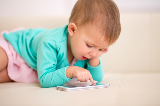 Kinder im Alter von anderthalb Monaten, die in einem Smartphone spielen.