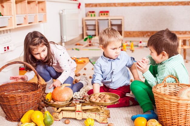 Kinder im Kindergarten spielen und erforschen das Konzept des Gleichgewichts mit Gewichten