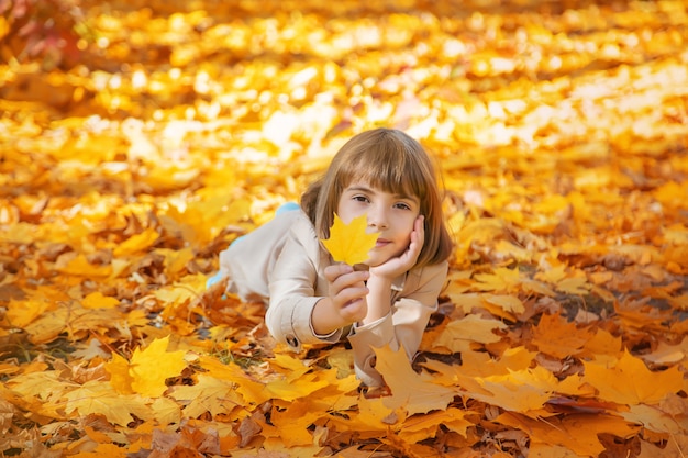 Kinder im Park mit Herbstlaub. Tiefenschärfe.