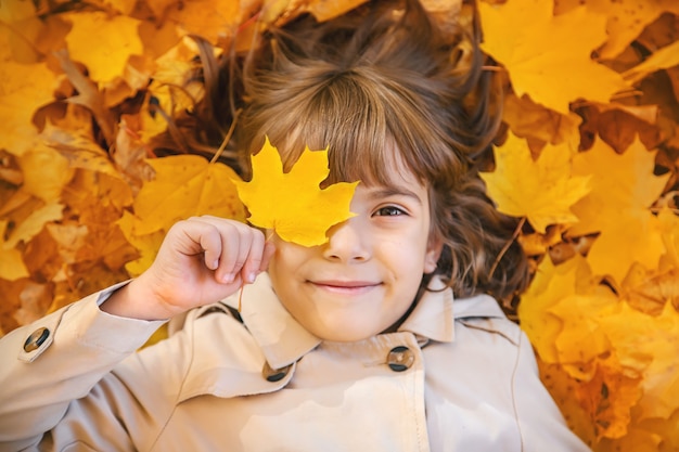 Kinder im Park mit Herbstlaub. Tiefenschärfe.