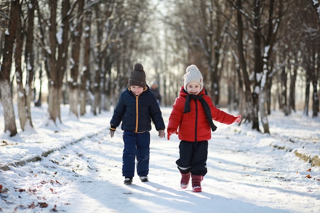 Kinder im Winterpark spielen mit Schnee