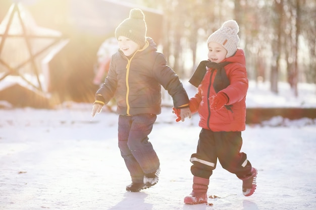 Kinder im Winterpark spielen mit Schnee