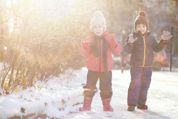 Kinder im Winterpark spielen mit Schnee