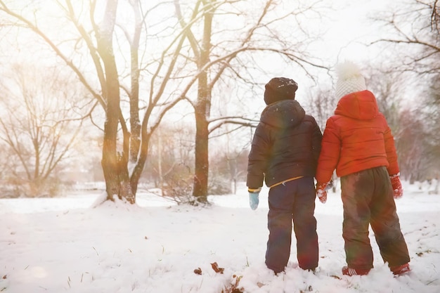 Kinder im Winterpark spielen mit Schnee