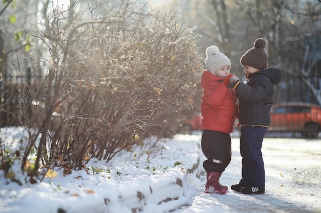 Kinder im Winterpark spielen mit Schnee