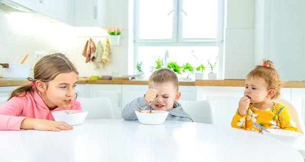 Kinder in der Küche am Tisch drehen Pasta selektiven Fokus