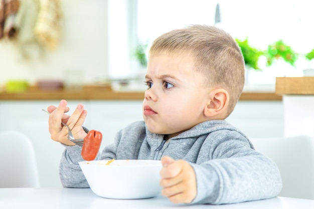 Kinder in der Küche am Tisch essen Nudeln